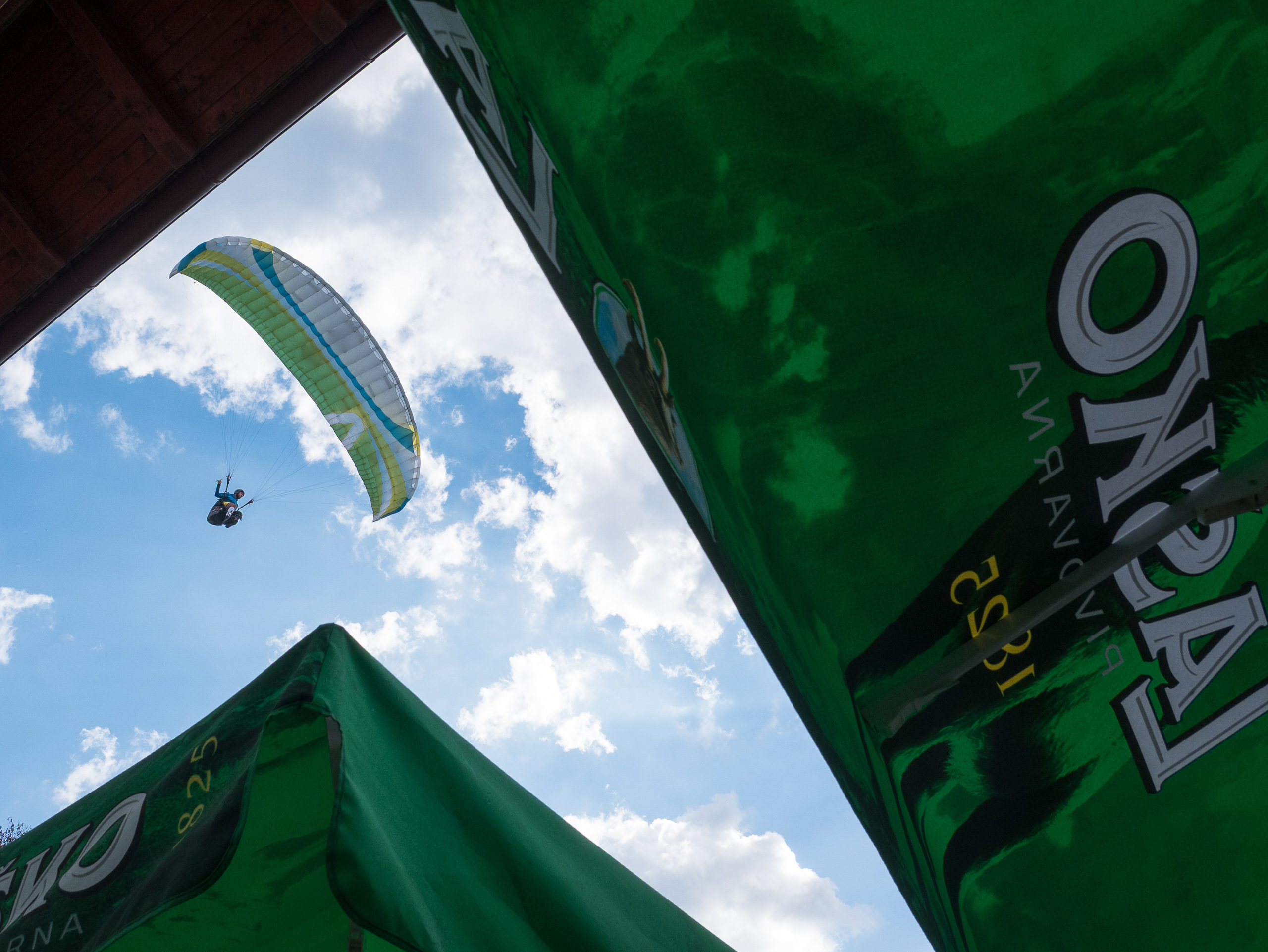 Gleitschirm über den Bierschirmen im Tal
